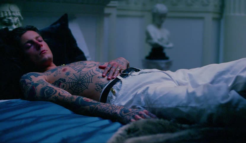 A man laying on a bed with his eyes close