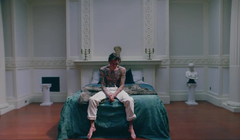 A man is sitting on a bed in a room
