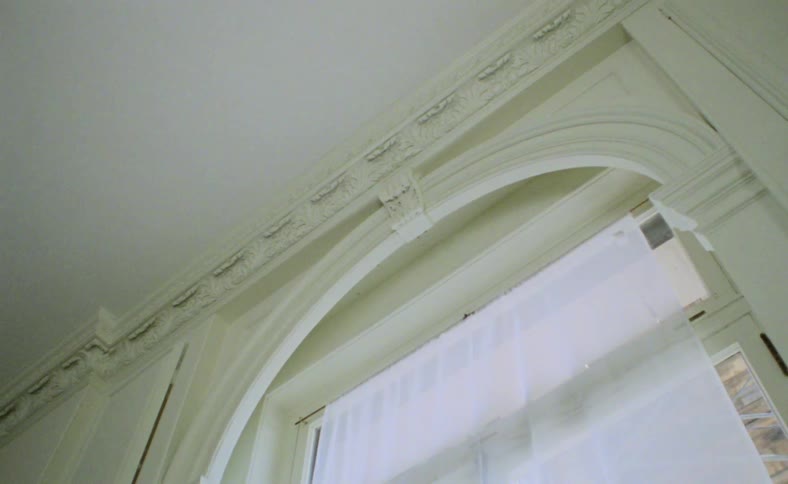 An arch window with a white curtain