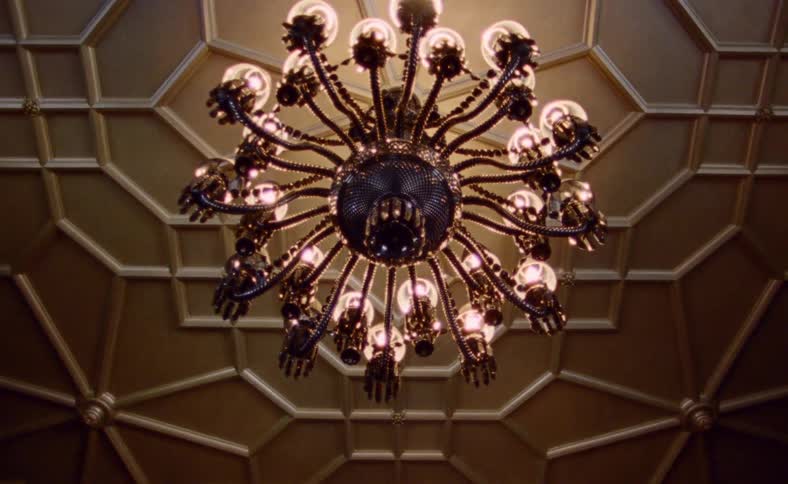 Chandelier hangs from the ceiling in the room