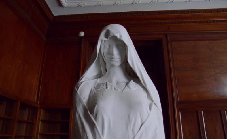 A statue sits in a wood paneled room