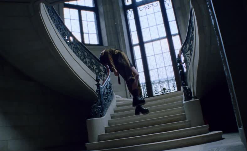 A young teen hangs in a staircase