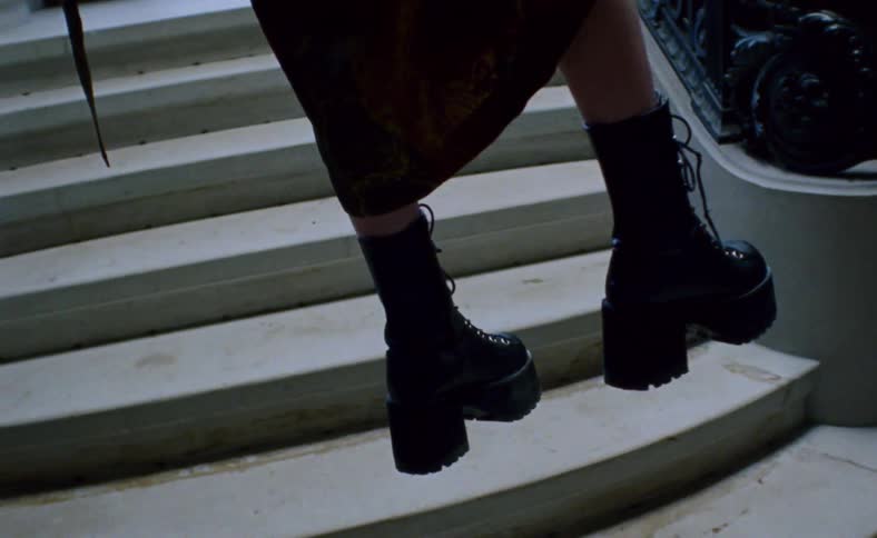 Woman floating over staircase inside mansion