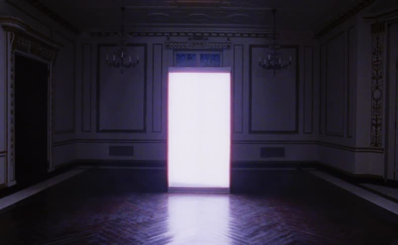 A room with chandeliers with a doorway with light