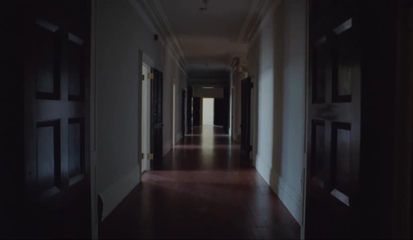 A camera moves through an empty hallway in a large building