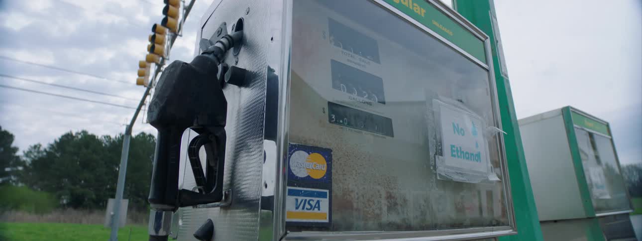 An old gas pump with a message taped to the front