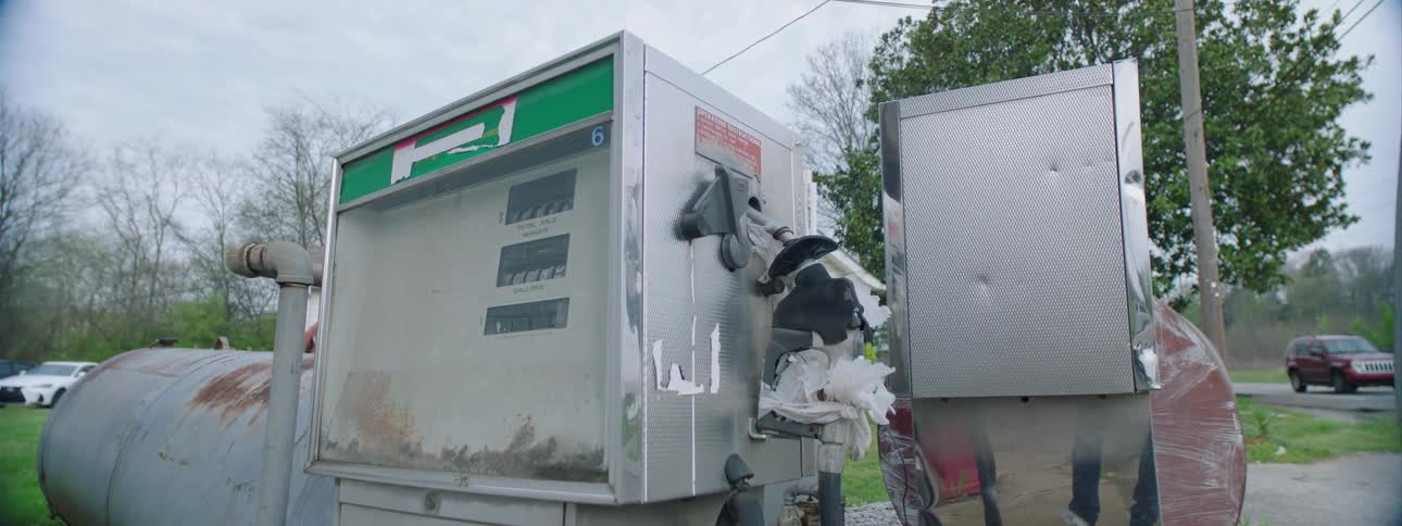 The gas station with a street and vehicles in the background