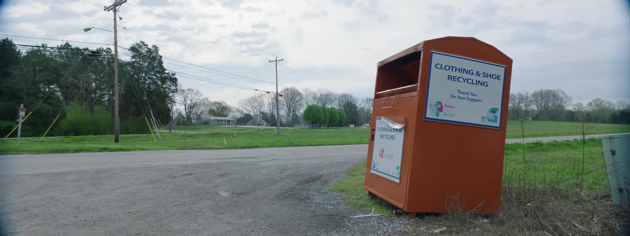 A donation container sits along a roadway