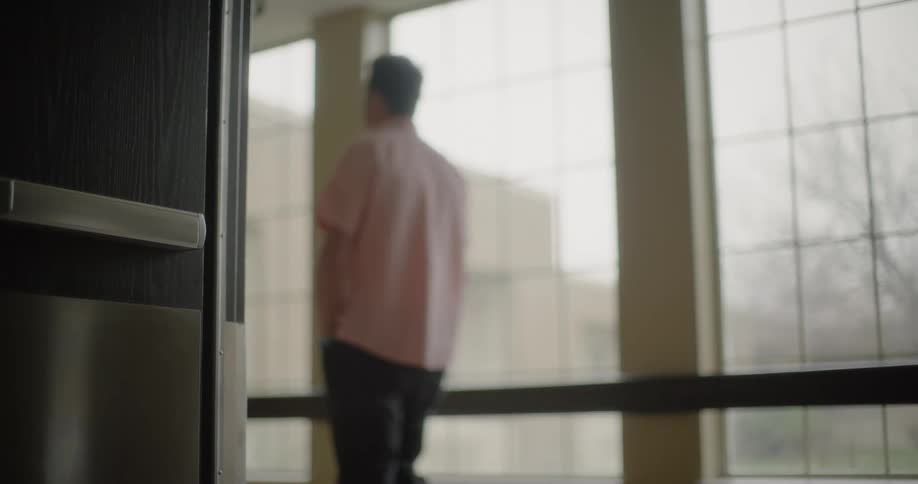 A man walking by next a large windows