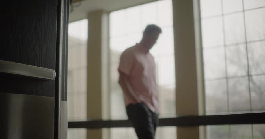 A man walking down a hallway lost in thought