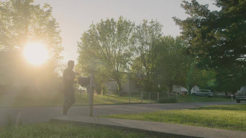 Man walking down to mailbox at end of his pathway