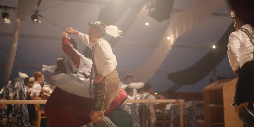 Couples wearing costumes dancing at an oktoberfest event