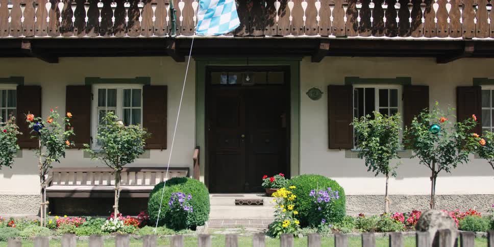 Plants and flowers adorn the front yard of a two story home