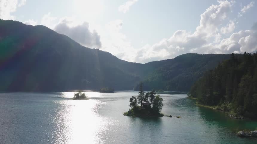 A river running between a low mountain ridge and a forest