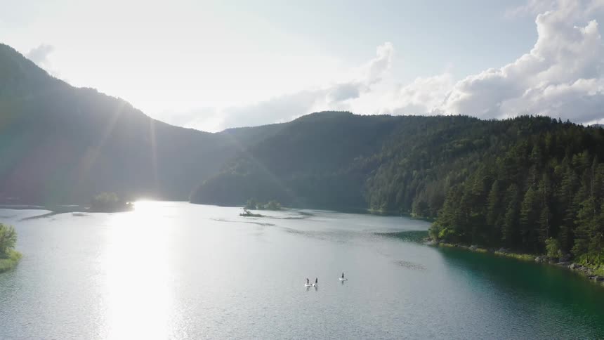 Three people paddle board on a lake