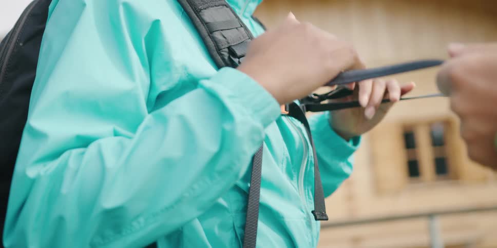 A man tightens the straps of the backpack