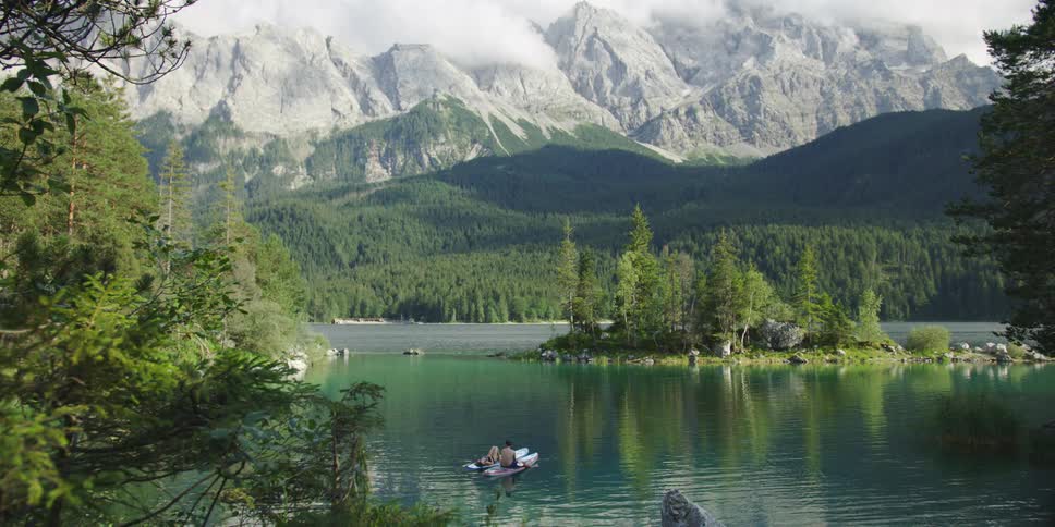 A single boat sits near the shore in the lake