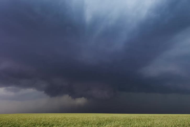 Dark clouds form over an open field