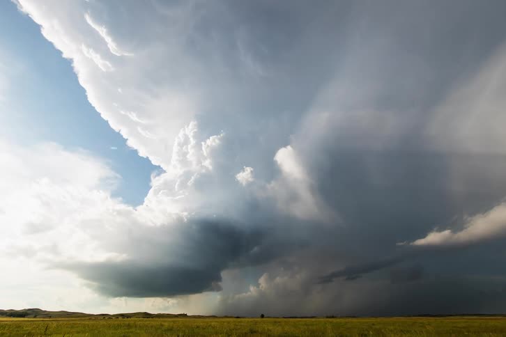 A grassy plain with clouds and the sky above