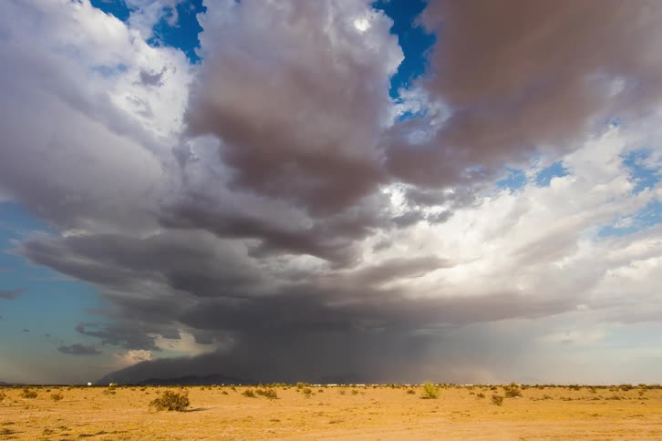 A strong microburst creates a dust storm that spreads across the desert