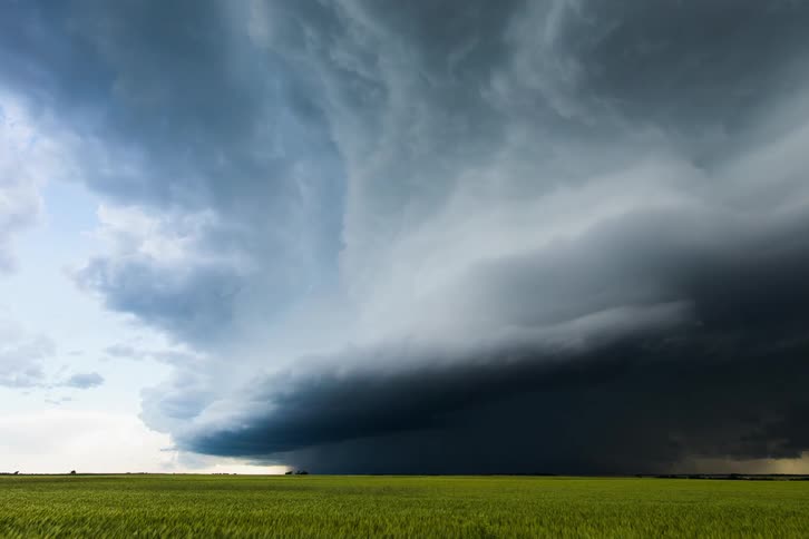 Storm clouds releasing rain over plains at day