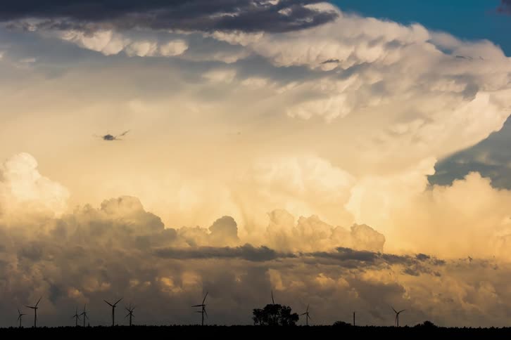 White clouds float in the sky at dusk