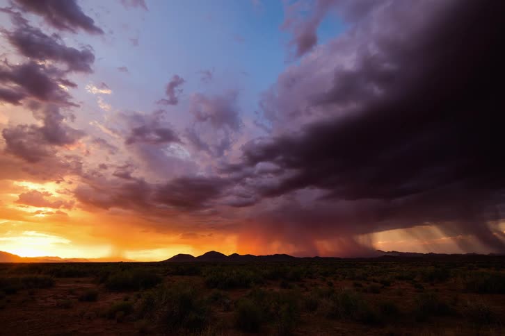 A desert with lightning and rain clouds above