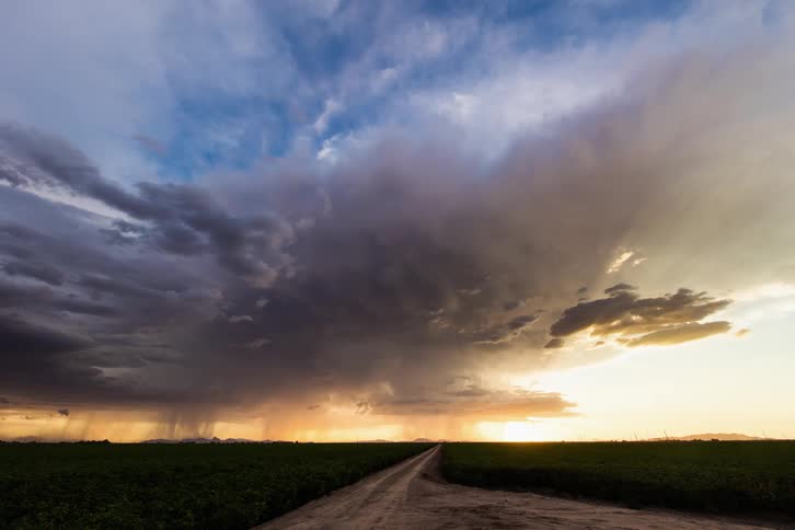 A huge storm cloud rolls over a flat plain