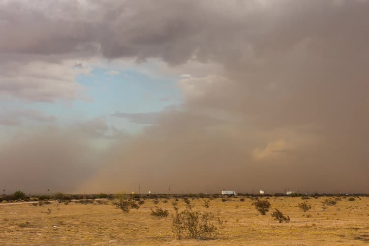 A dust storm moves over a desert