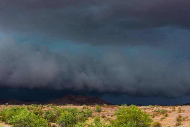 Storm clouds roll over a desert landscape