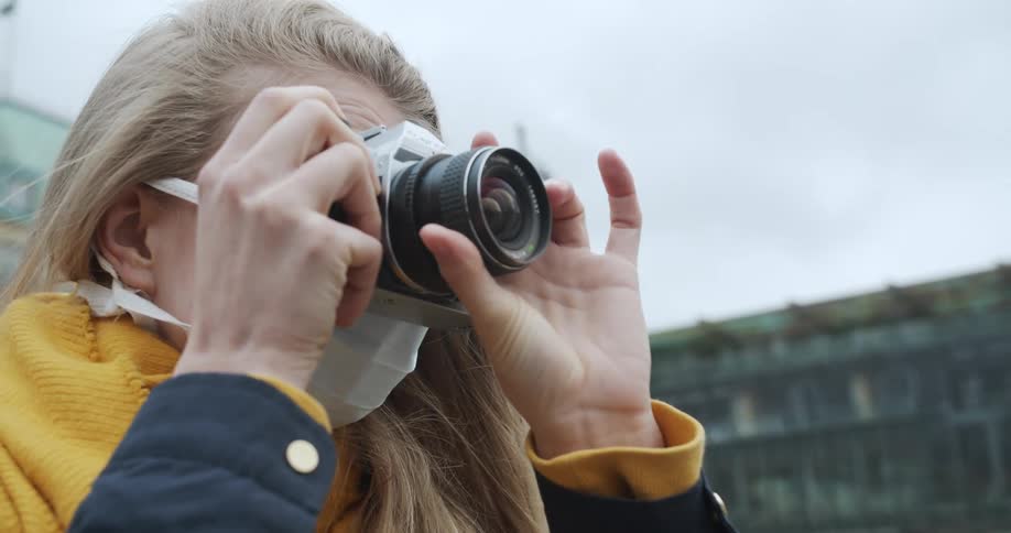 A teenager takes photos outside