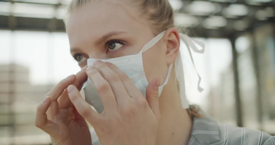 A woman fixes her face mask