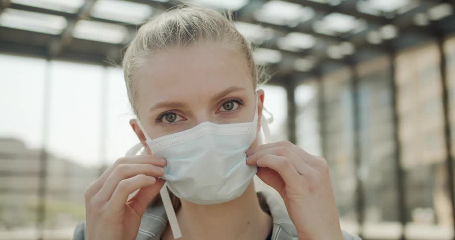 A woman fixes her face mask