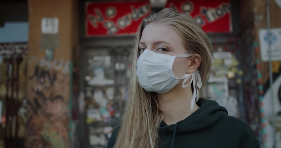 A woman is outside wearing a face mask