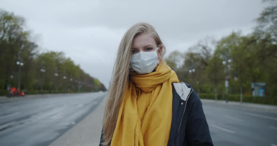 A woman standing outside with a mask on