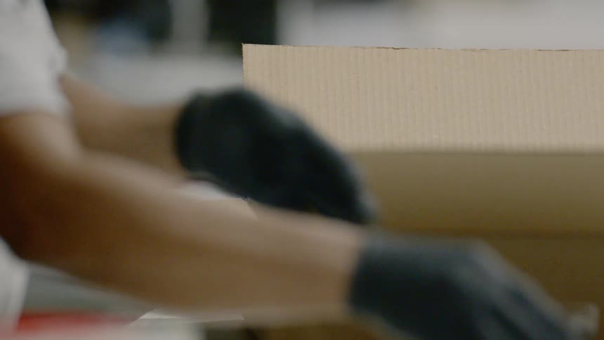 A worker packing ppe into a box