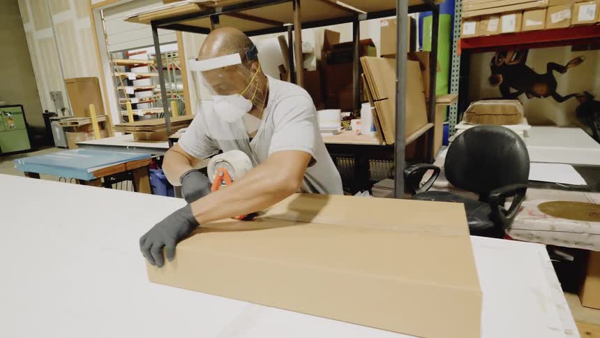 A man prepares a package to ship