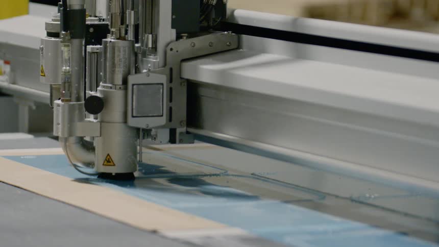 The machine carves shapes in the plastic
