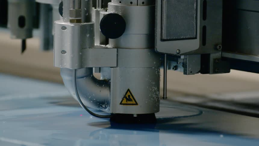 The machine cuts the plastic sheet