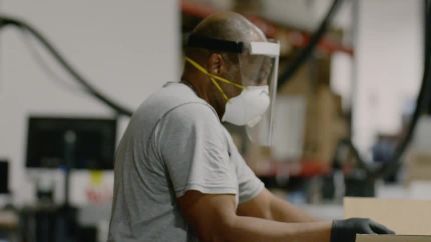 A person packing ppe in a box