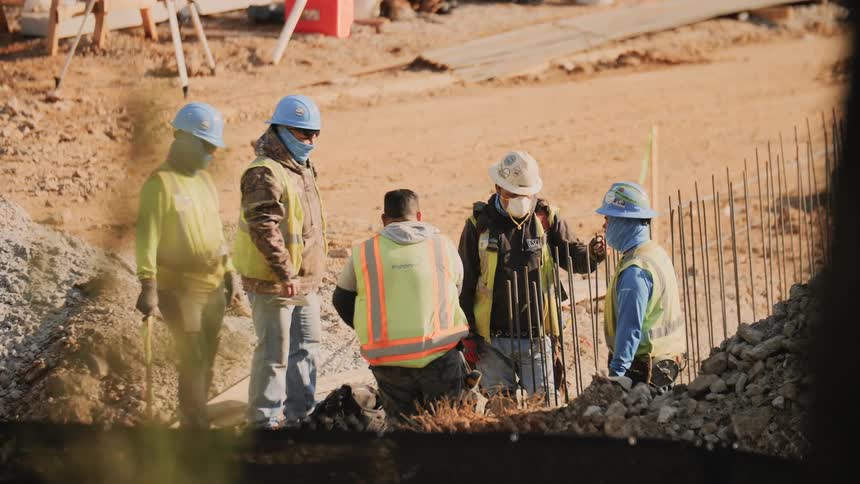 A construction crew stands outside and talks