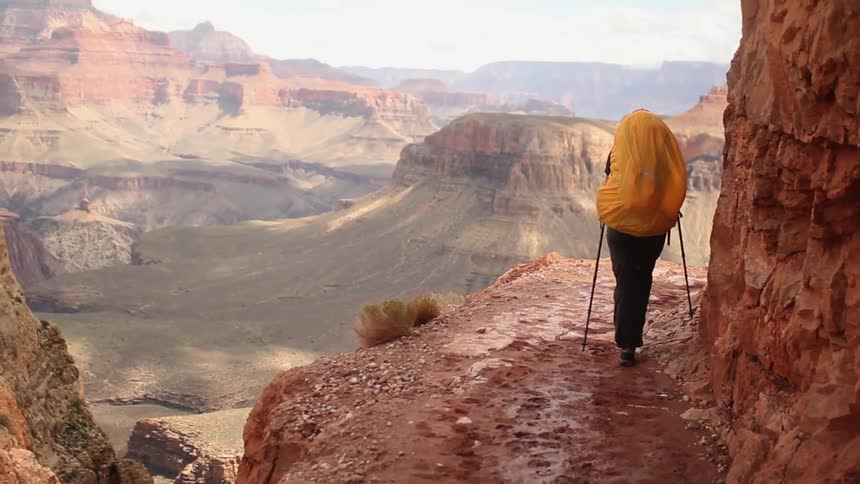 A person wearing a backpack hiking over the mountains