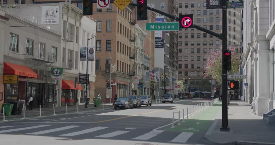 Only a few pedestrians are present on a city block near an intersection