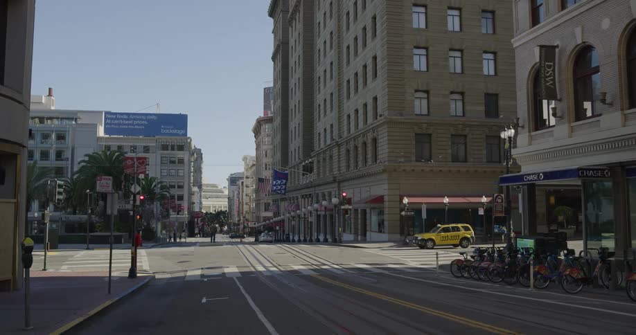 A yellow car waits at a city intersection