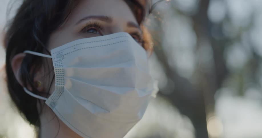 A woman in a face mask standing outdoors