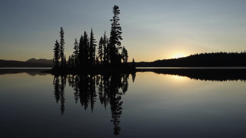 Looking out over a calm lake at sunrise