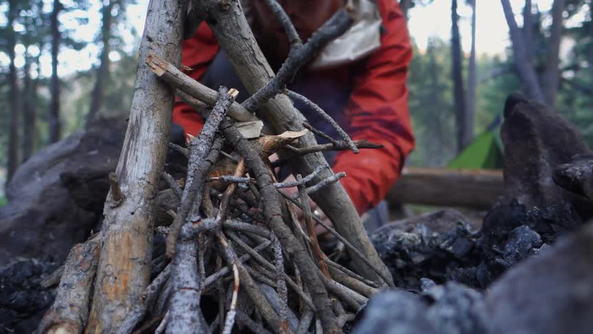Someone building a fire at camp
