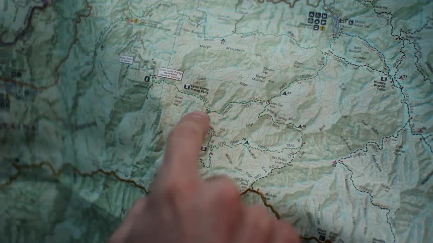 A finger traces a route on a map