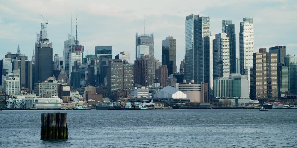 Ocean waves are moving towards the coast of a downtown city
