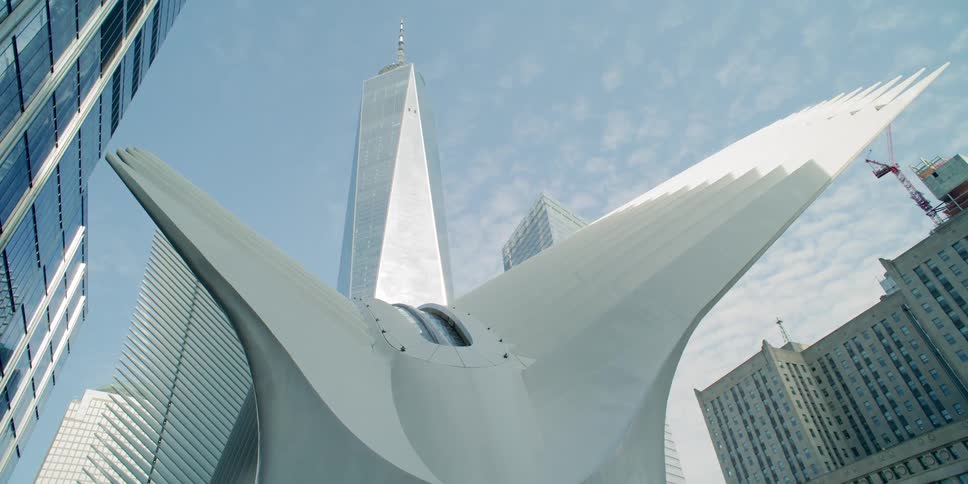 An aluminum sculpture is surrounded by tall skyscrapers downtown